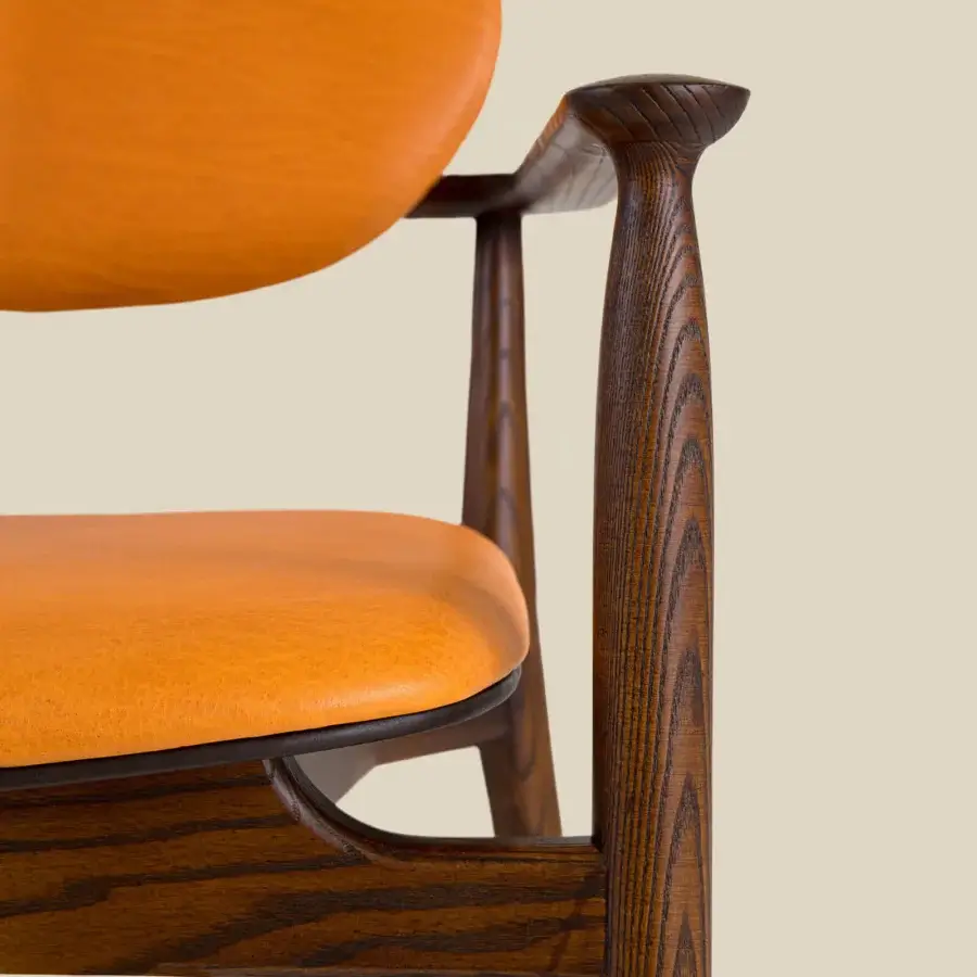 Elegant Borzalino Regina lounge chair with vibrant orange leather upholstery and dark brown stained wood frame