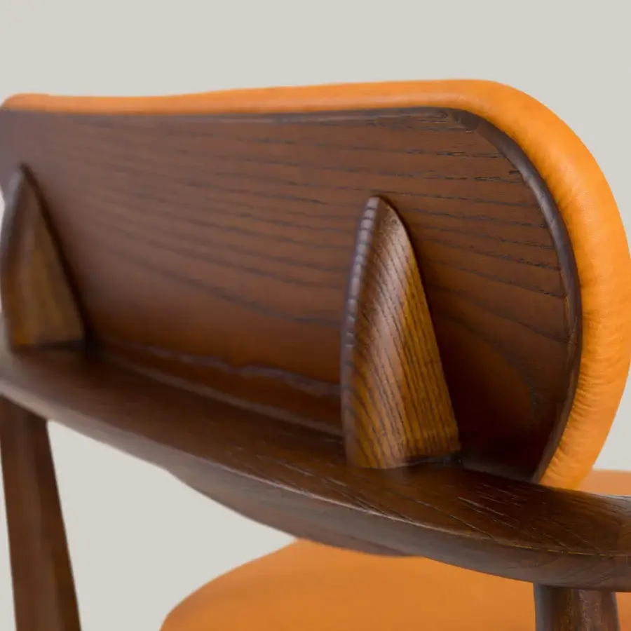 Exceptional Borzalino Regina lounge chair with captivating orange leather-like upholstery and dark-toned wood finish
