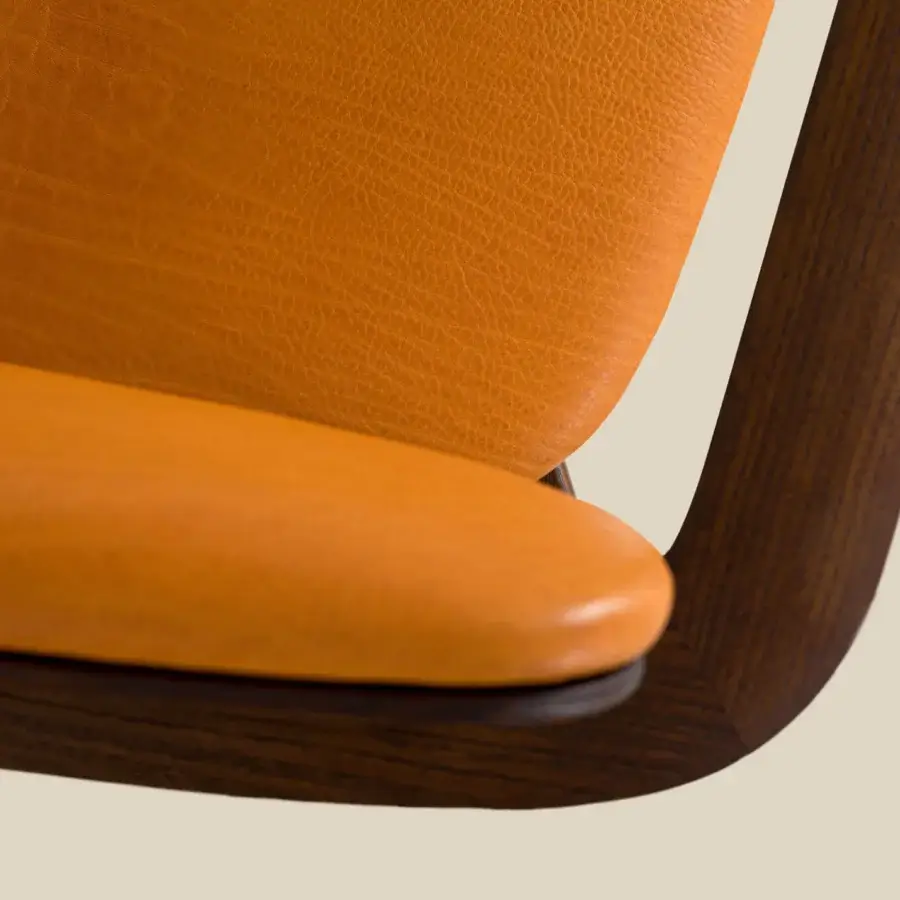 Superior Borzalino Regina lounge chair crafted with vibrant orange leather and a dark brown wood finish