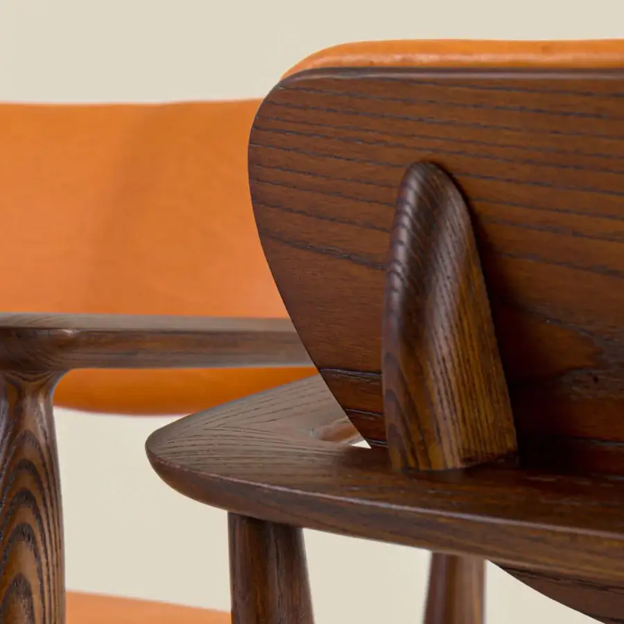 Elegant Borzalino Regina lounge chair with vibrant orange textile upholstery and dark brown wood grain finish