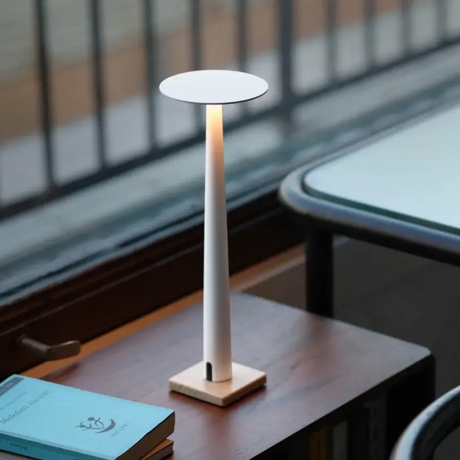 Elegant Nemo Portofino table lamp in aluminum with a matte white finish emits a warm ambient glow from its circular shade and light base