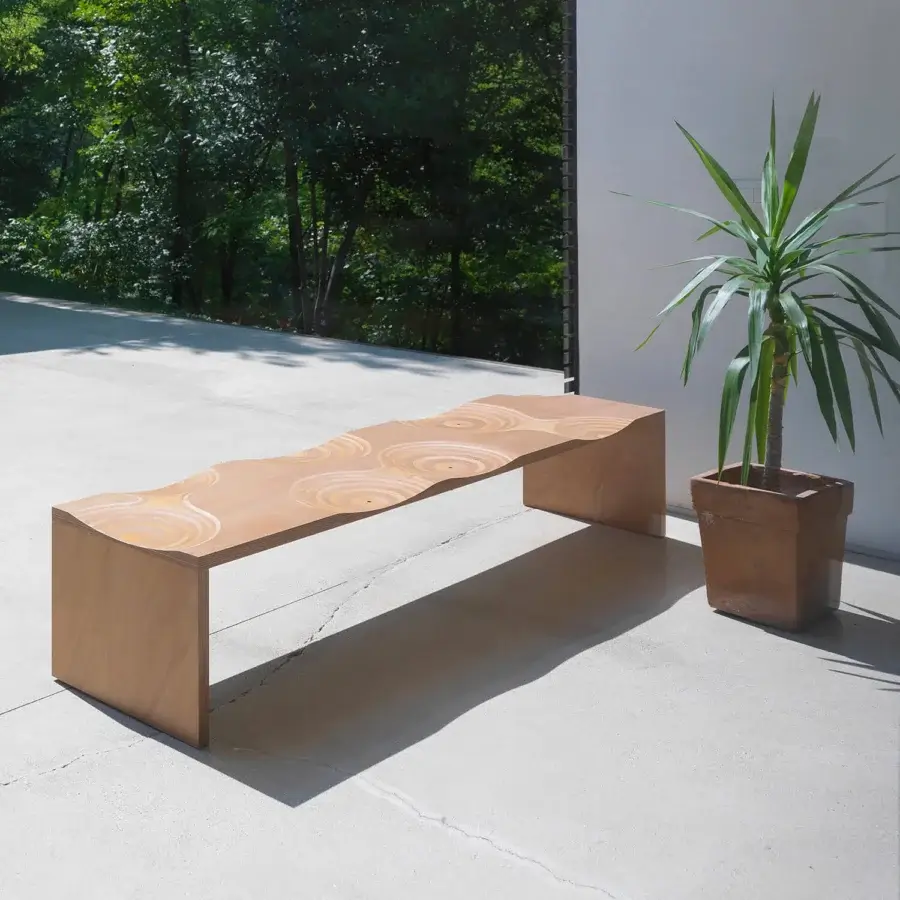 Innovative Horm Ripples bench crafted in Italy with concentric circles in light okoume wood exhibiting a minimalist finish