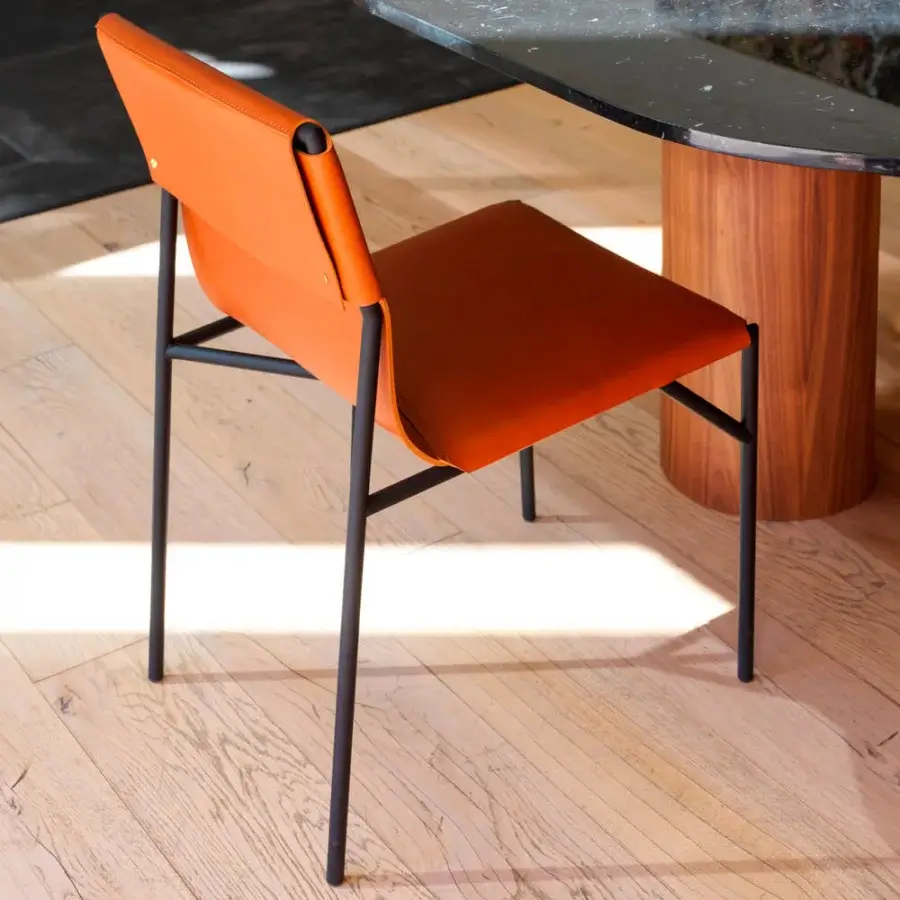 Sophisticated Horm Tout Le Jour chair with orange seat and backrest built in black metal and high-end leather