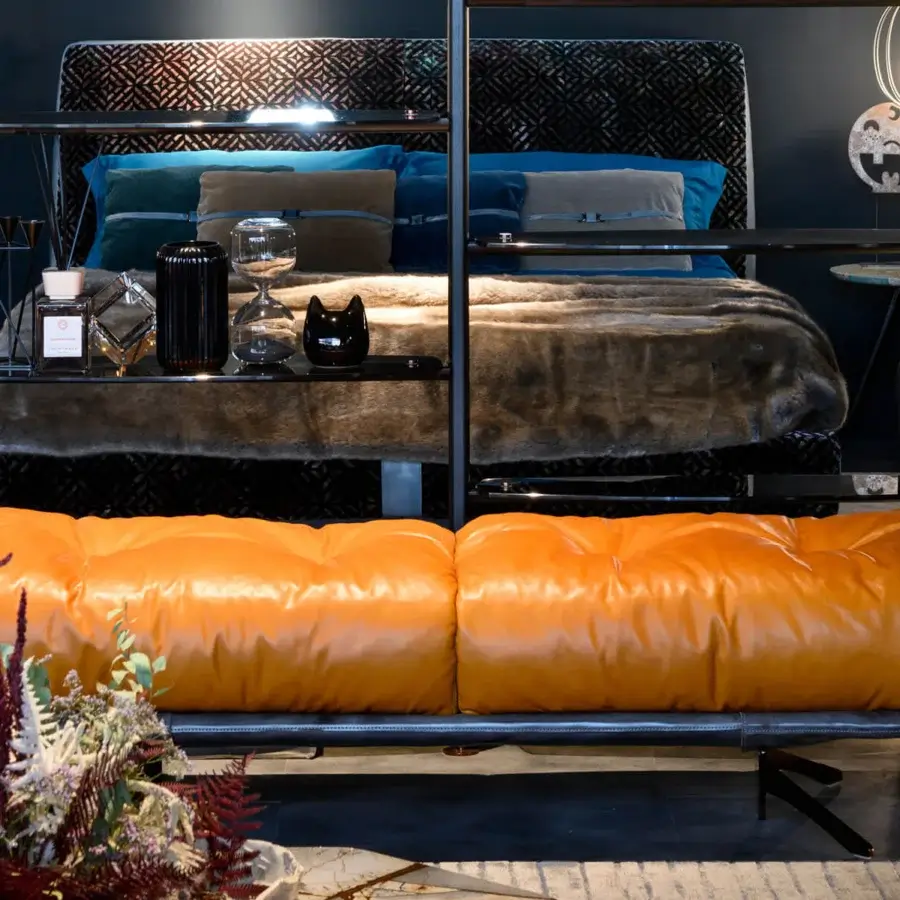 Elegant Borzalino Ayton bench with a curved metal tube frame upholstered in vibrant orange synthetic material and leather cushions