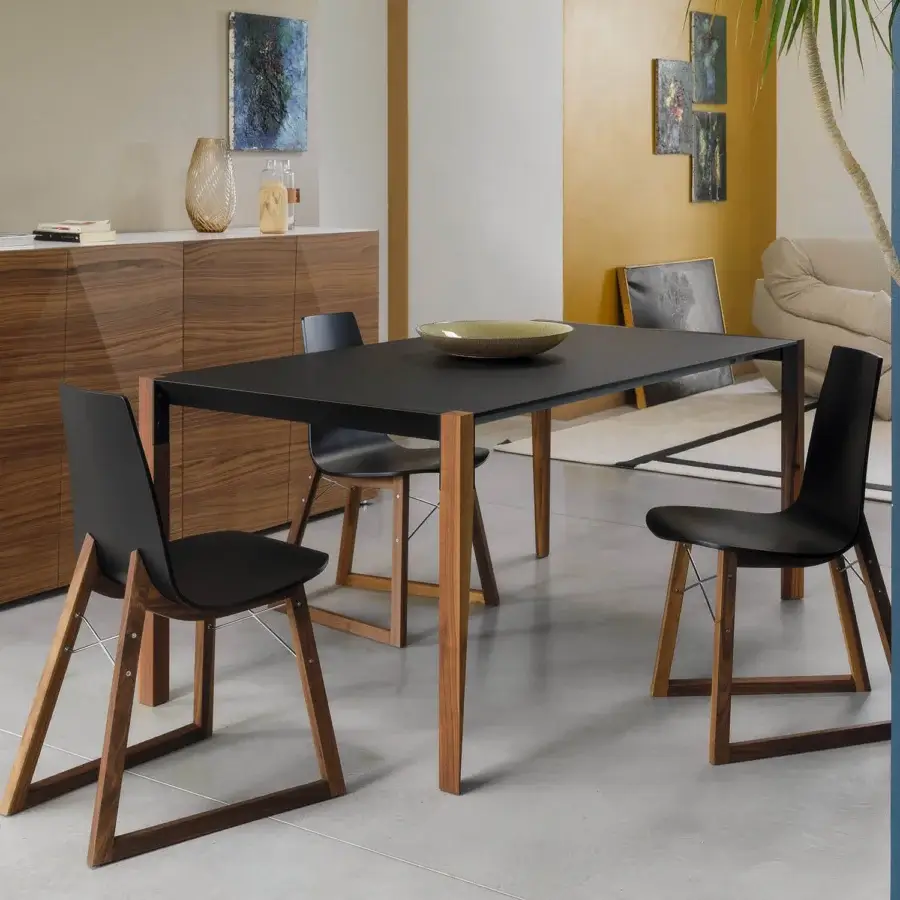 Elegant Horm Tango table with sleek black Fenix tabletop and sinuously shaped walnut-toned wooden legs crafted in Italy