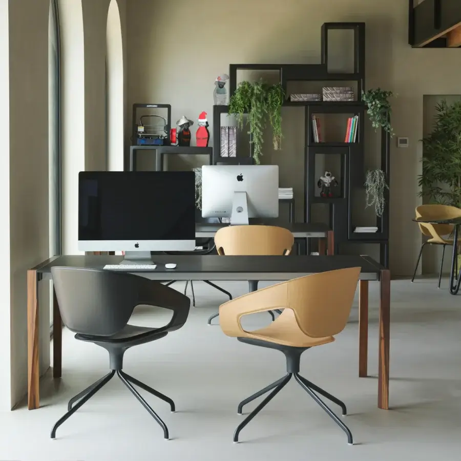 Innovative Horm Tango table crafted in Italy with a dark matte Fenix tabletop and angled wooden legs displaying visible grain