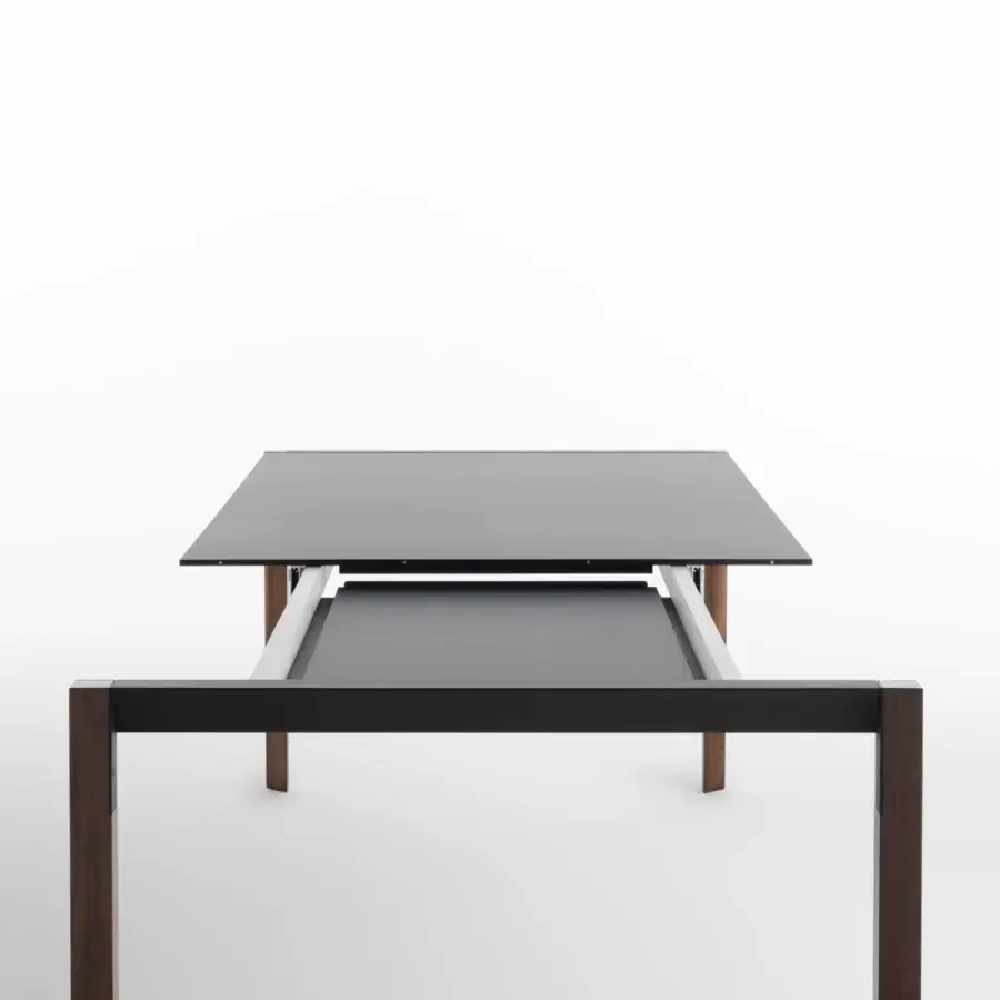 Innovative Horm Tango extendable table with a dark matte Fenix tabletop and dark-toned wooden legs built with black metal supports
