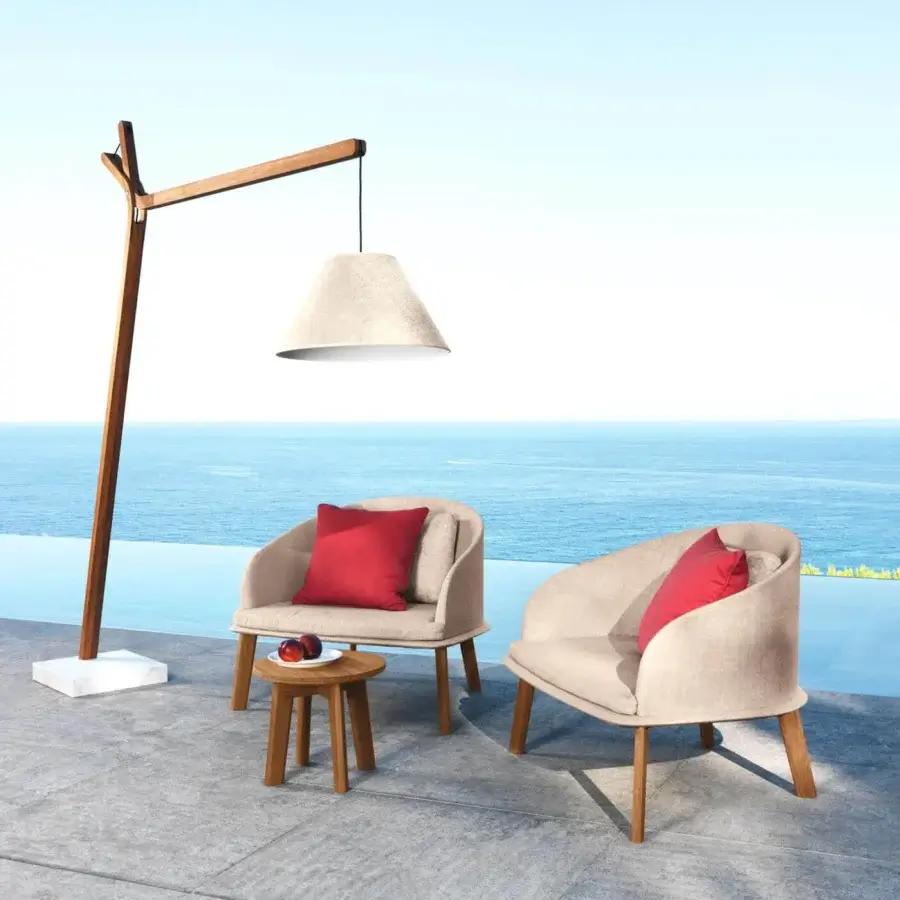 Distinguished Talenti Cleo lounge chair with a curved silhouette and weather-resistant removable beige fabric complemented by a vibrant red pillow
