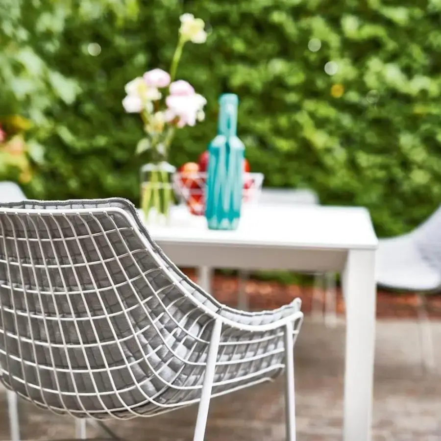 Sophisticated Varaschin Summer Set armchair with a curved silhouette and dark gray textile seat in a light powder-coated steel grid frame