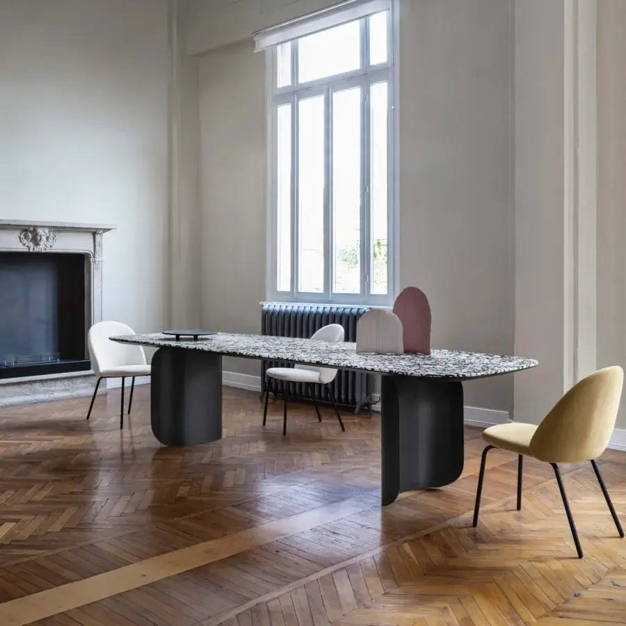 Sophisticated Miniforms Barry table with a speckled black and white composite tabletop and matte black cylindrical legs crafted in intriguing volumes