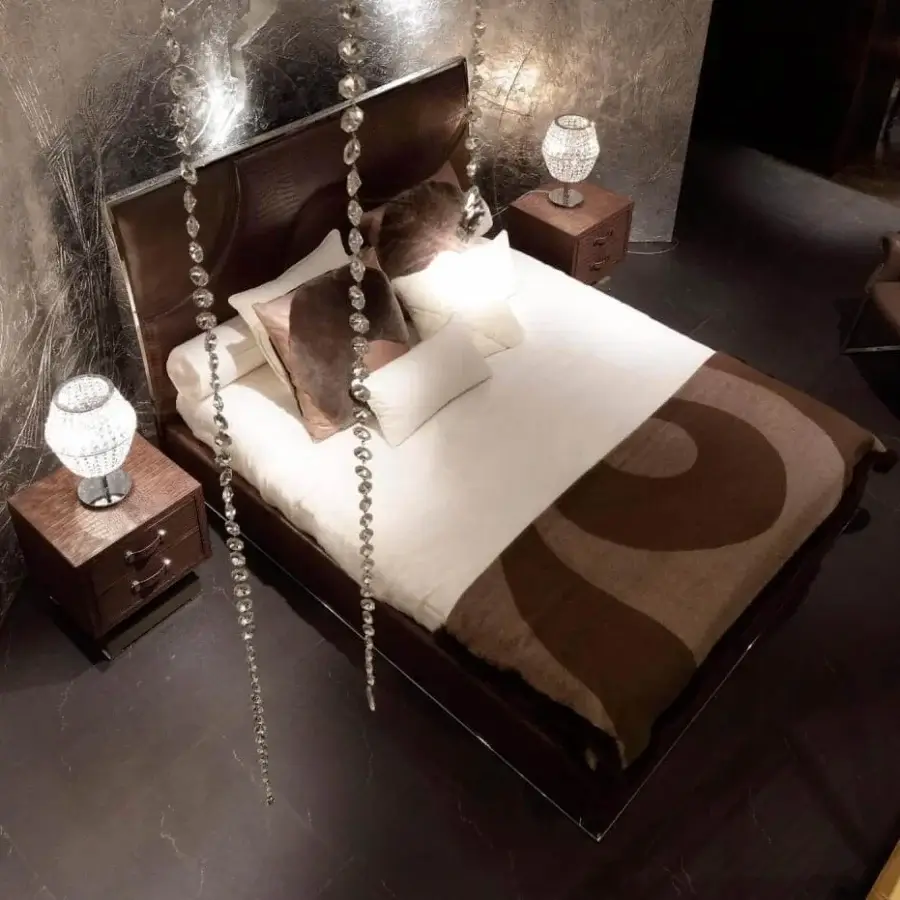Superior Rugiano Riflesso bed with dark brown fabric or leather and wave-patterned stitching in bronze or steel finish