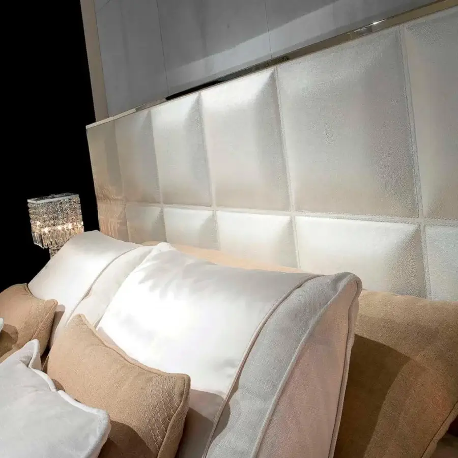 Distinguished Rugiano Gemma bed upholstered in white leather with a padded square headboard and bronze-toned metal trim