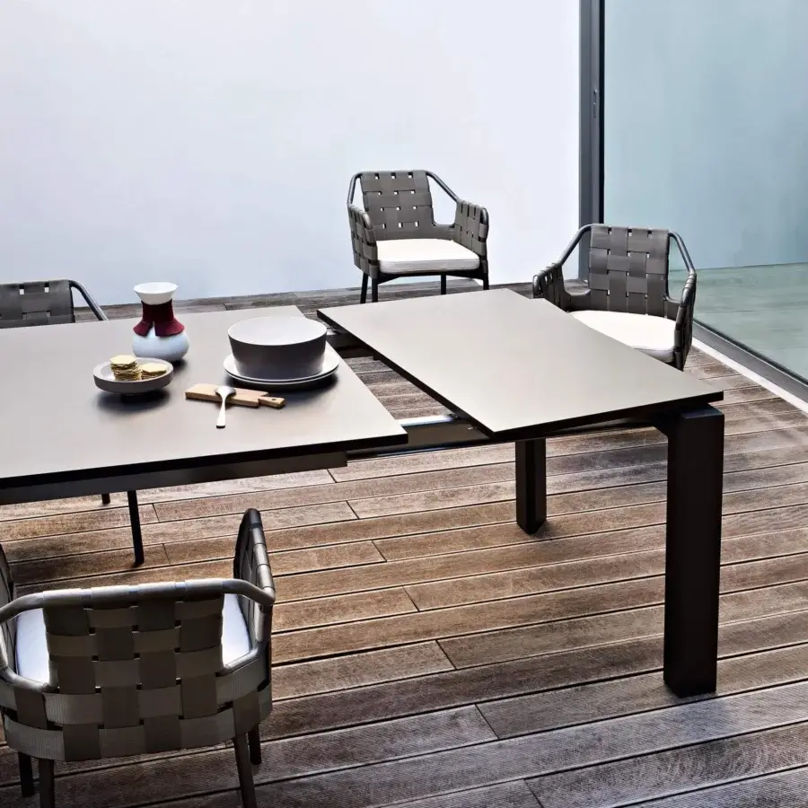 Elegant Varaschin Dolmen table with angular lines, dark gray HPL top and powder-coated aluminum frame built for outdoor use