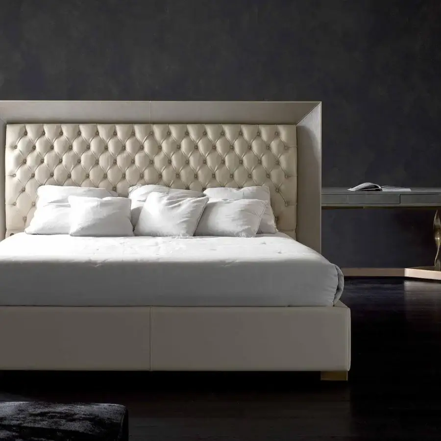 Lavish Rugiano Kenya bed with a fabric-covered base and leather-framed tufted headboard in light cream hues