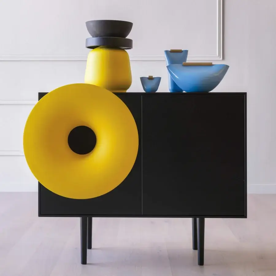 Superior Miniforms Caruso bar cabinet with a sleek black silhouette and vibrant yellow donut-shaped speaker