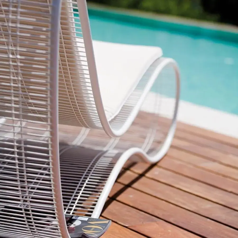 Superior Talenti Breez lounger with a curved silhouette crafted in steel and white resistant fabric with a glossy coating
