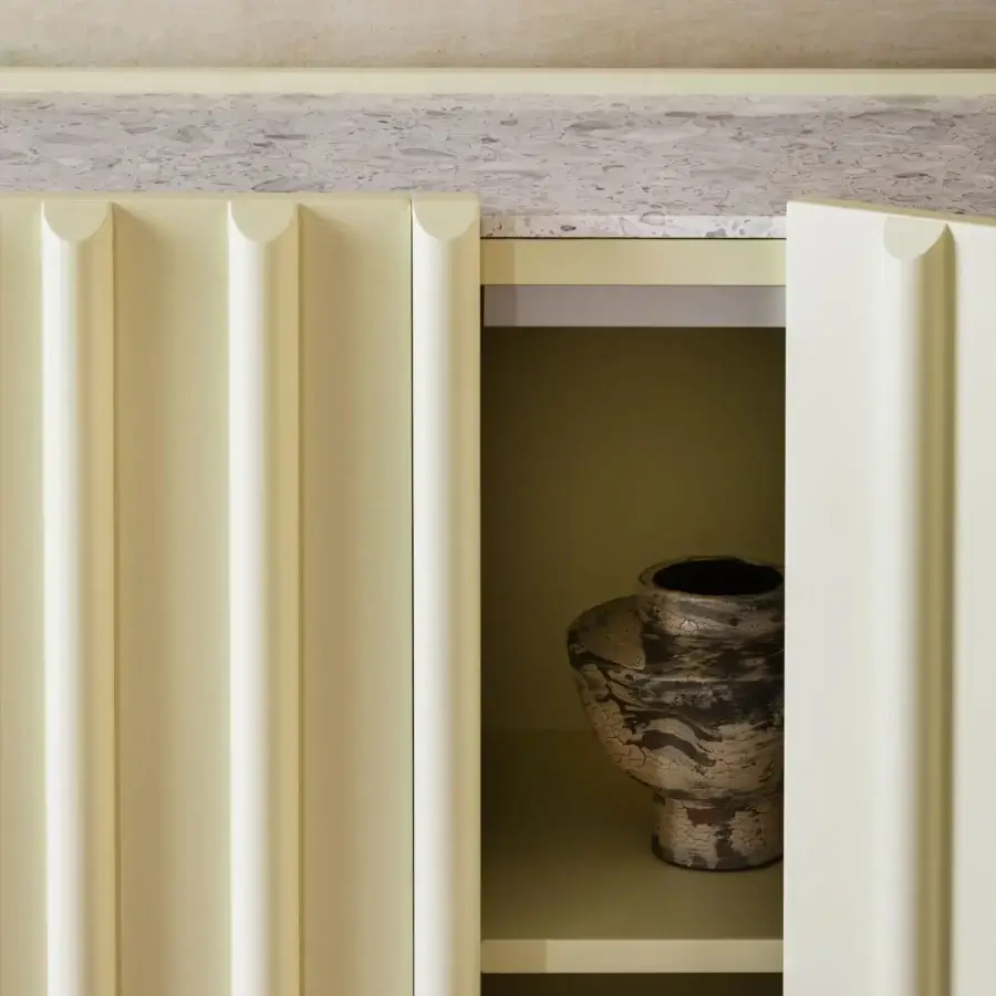 Superior Miniforms Containerup bar cabinet with vertically ridged pale yellow lacquer and speckled stone countertop