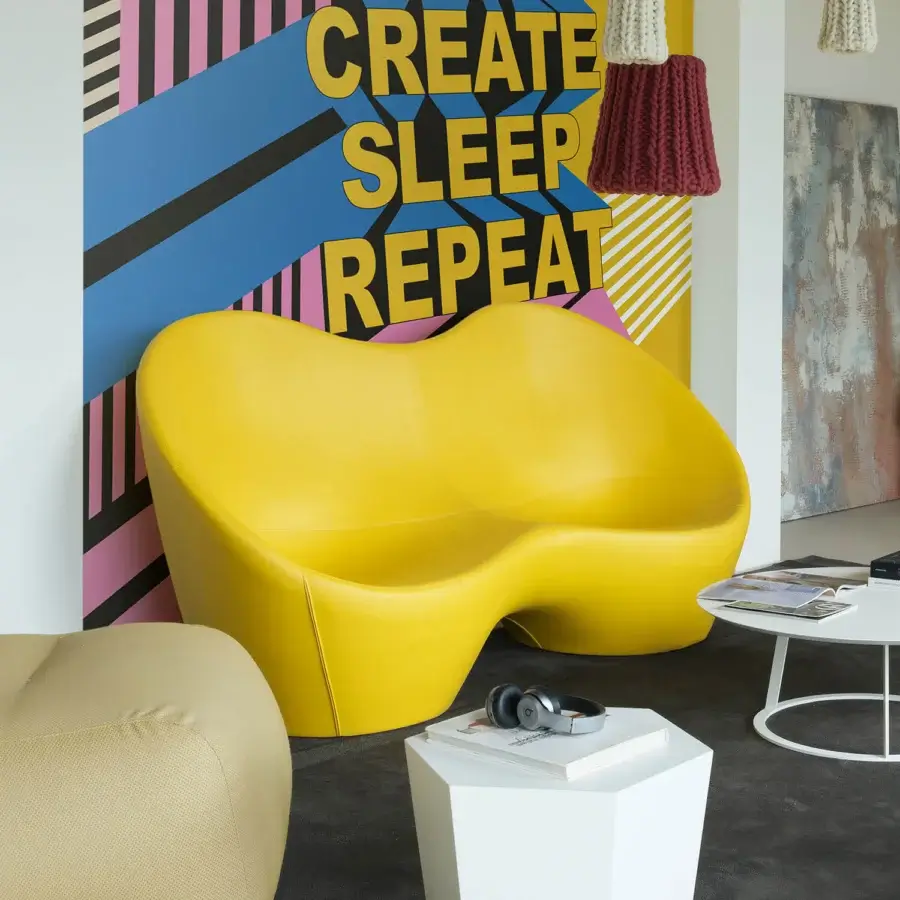 Superior Casamania Kouch sofa presents a voluptuous curved form upholstered in bright yellow fabric or leather with a smooth glossy finish