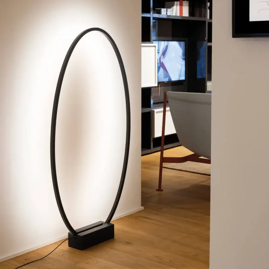 Superior Nemo Ellisse floor lamp with a matte black elliptical frame and bright white light built on a black marble base
