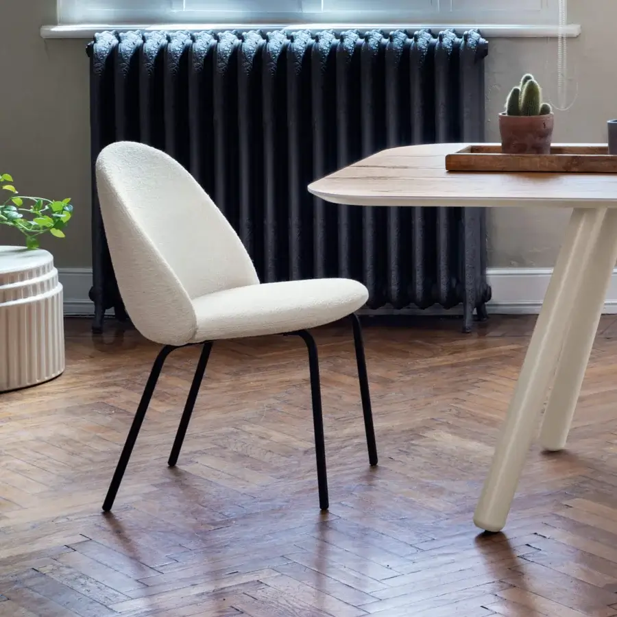 Elegant Miniforms Iola chair with expanded polyurethane shell and textured light off-white boucle fabric upholstery, built with matte black metal legs