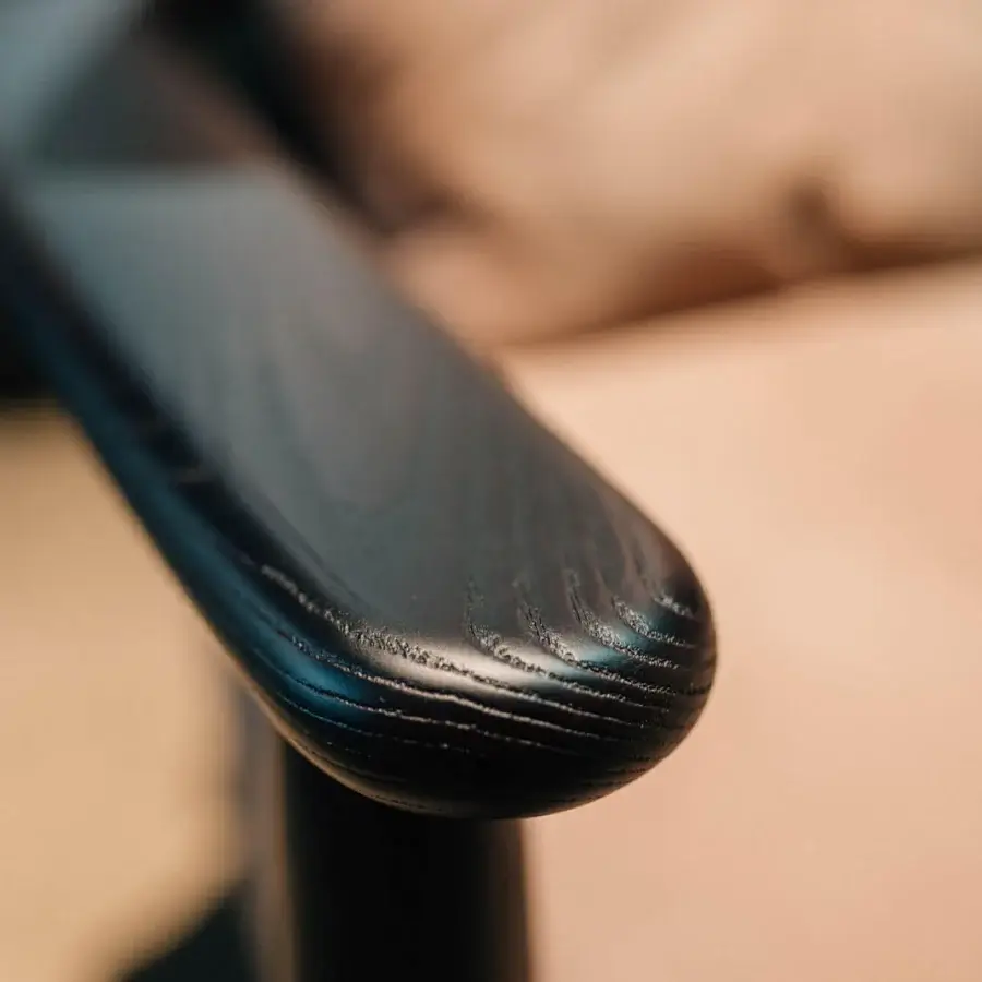 Elegant Borzalino Lisa lounge chair with tan cushioning and lacquered oak armrests displaying a dark glossy finish