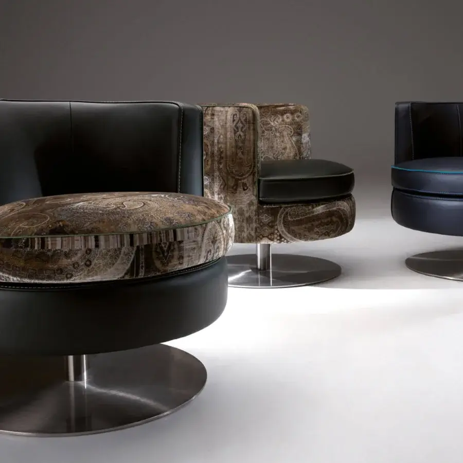 Handcrafted Borzalino Frisbee lounge chair with smooth black leather upholstery and paisley textile cushion built on a swivel metal base