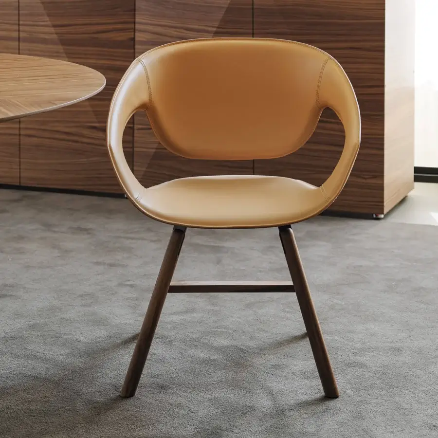 Elegant Casamania Vad armchair with curved lines and tan premium hard leather upholstery built with a wooden base