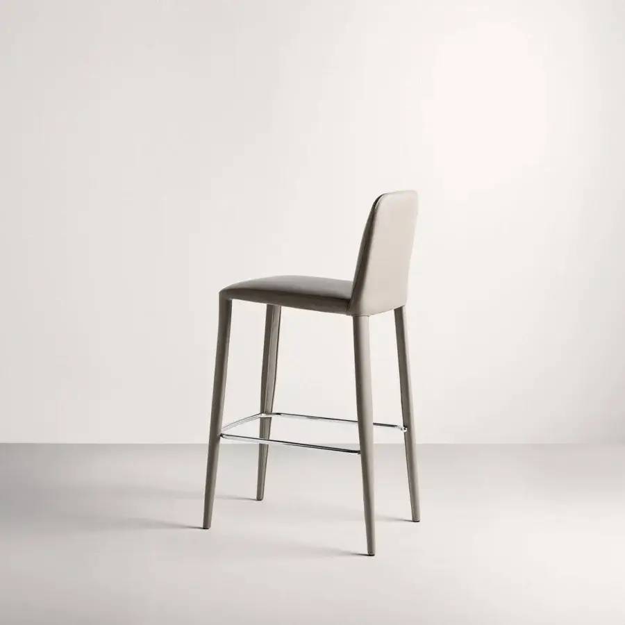 Superior Frag Elf stool showcases sleek geometric form fully upholstered in light gray with smooth matte finish and chrome footrest