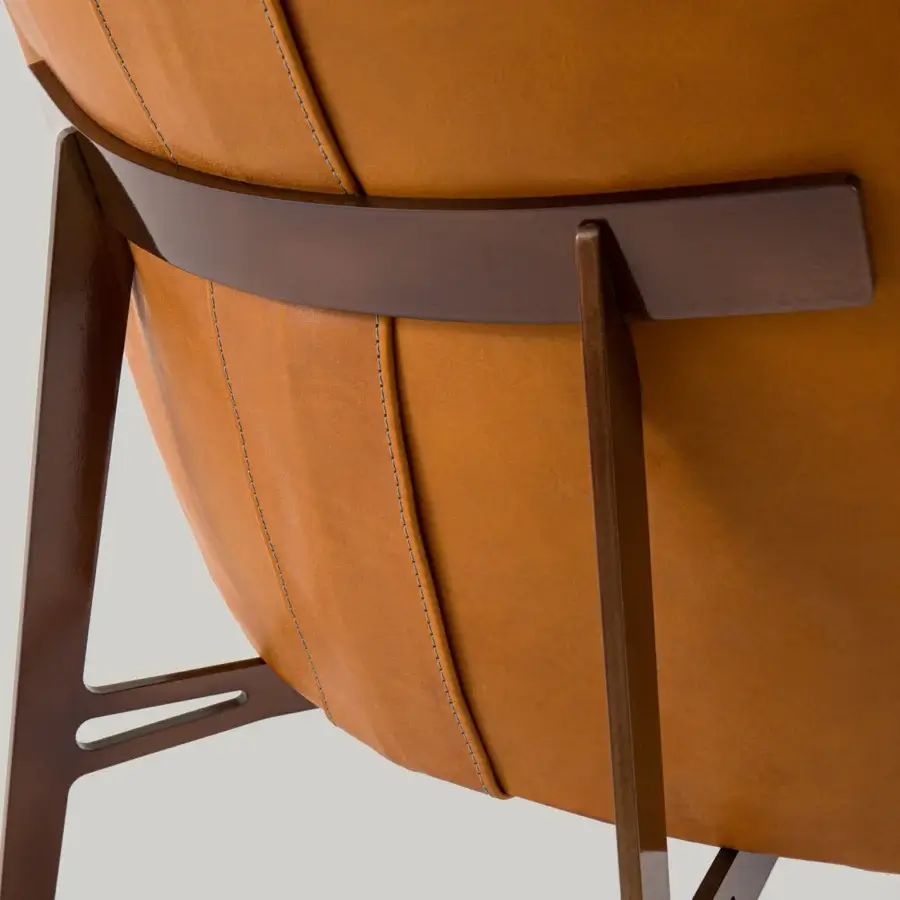 Elegant Borzalino Mia lounge chair upholstered in tan leather with a matte lacquered metal base and polished brown wood support