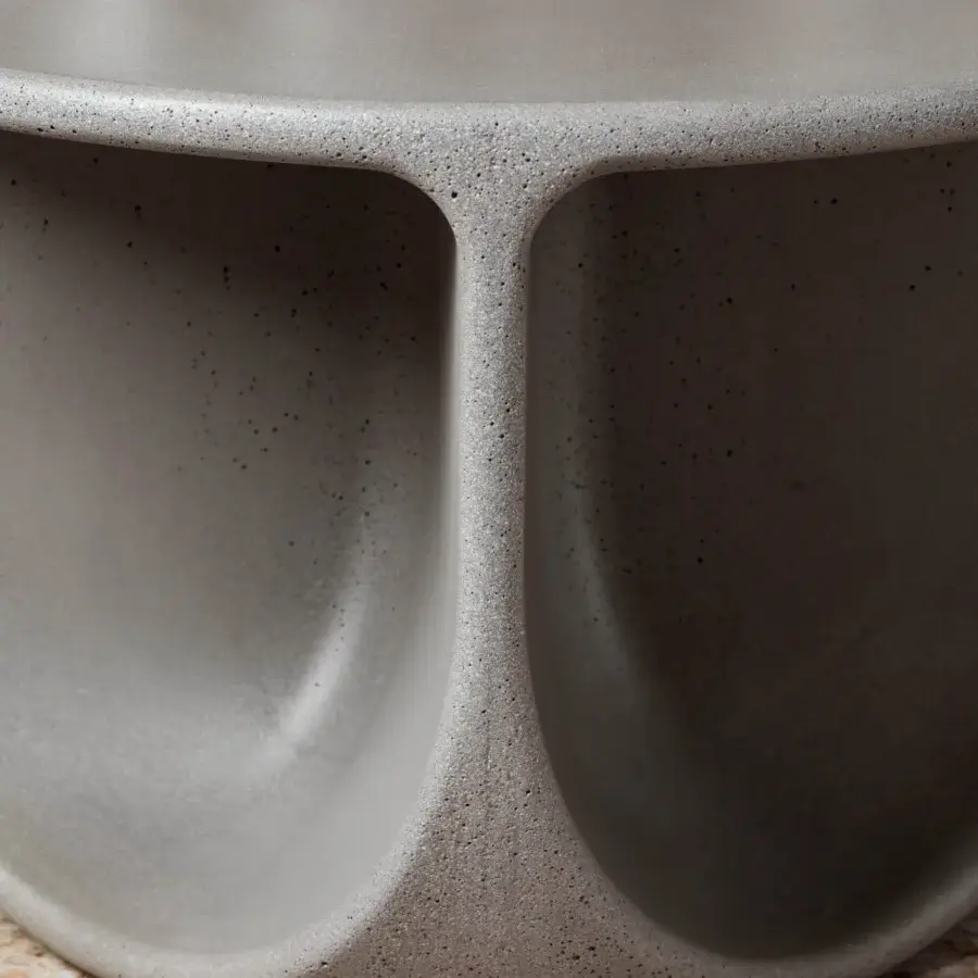Exceptional Miniforms Pinto coffee table with curved openings and a matte concrete-like finish in varying shades of gray