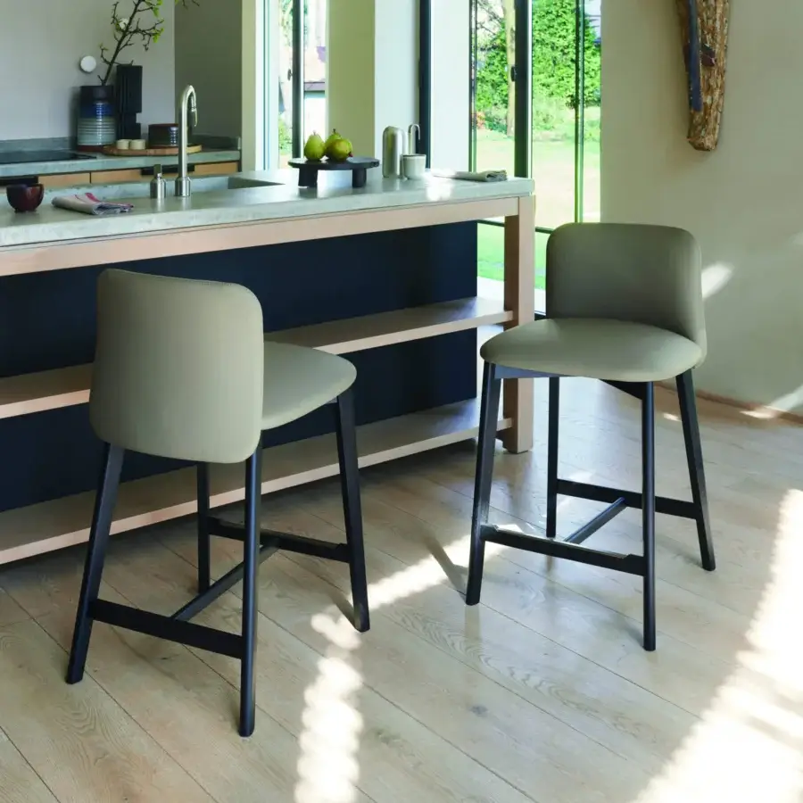 Harmonious Frag Siloe stool with muted olive green synthetic upholstery and a dark metal frame built with satin stainless steel inserts