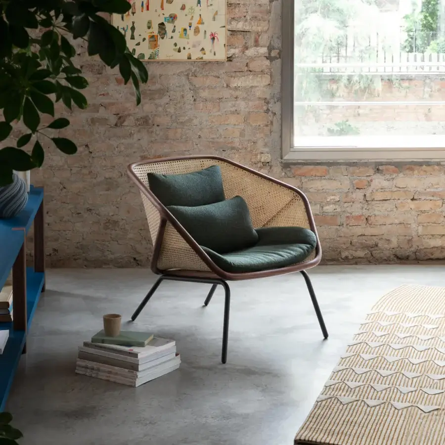 Elegant Miniforms Colony lounge chair with enveloping structure, woven rattan and dark green textile cushions with matte finish