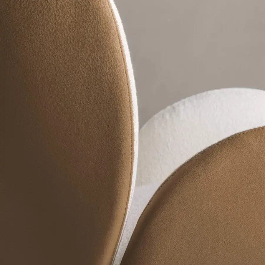 Distinguished Frag Ocean lounge chair with light brown leather exterior and fuzzy white interior cushions built with a central steel swivel base