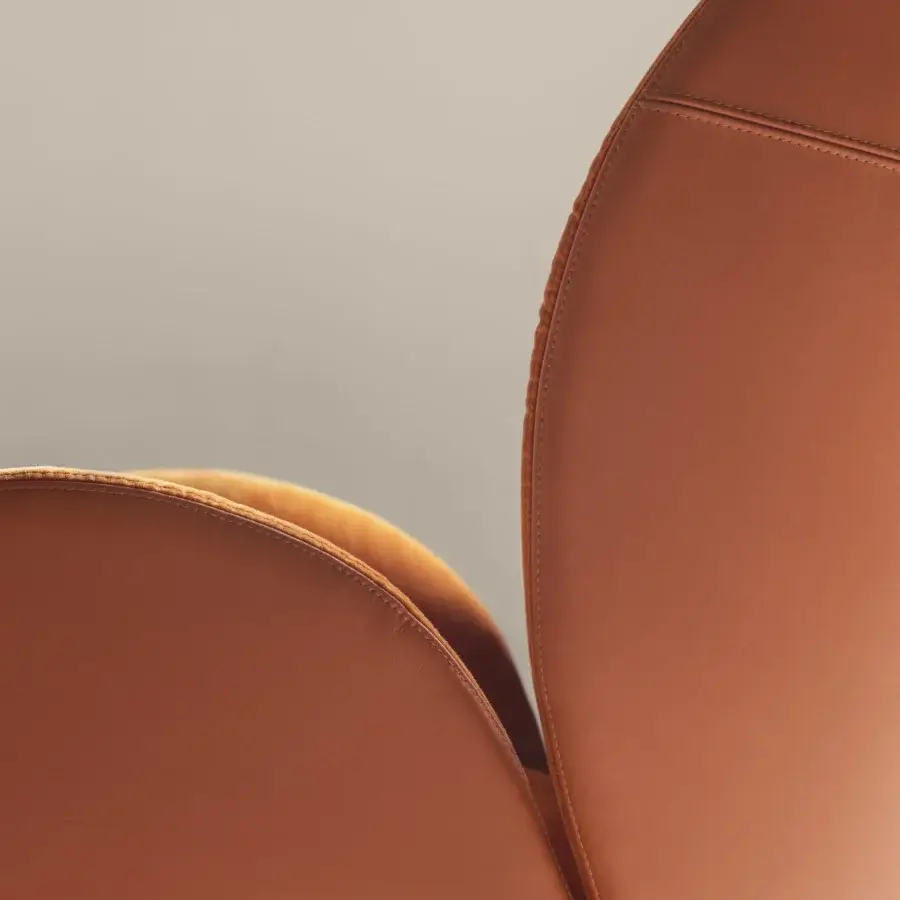 Superior Frag Ocean lounge chair with reddish-brown leather upholstery, curved silhouette and central steel swivel base