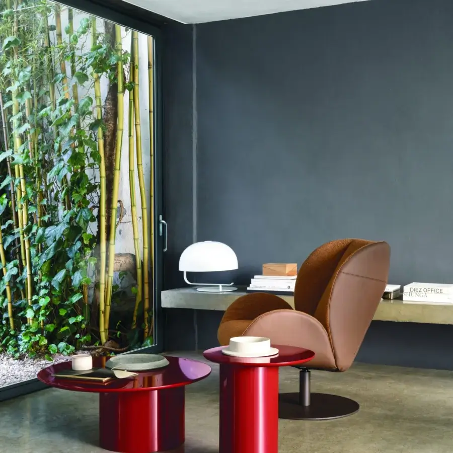 Elegant Frag Ocean lounge chair with a swivel steel base, warm brown leather and tan fabric upholstery