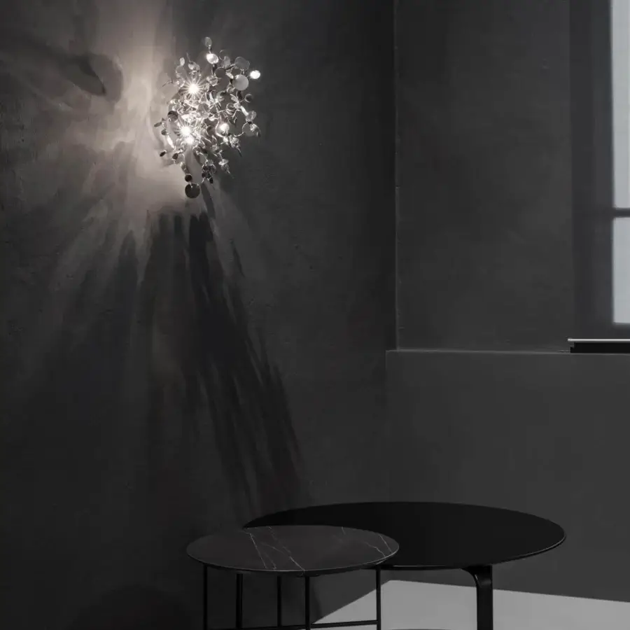 Exceptional Terzani Argent wall lamp handcrafted with reflective silver metal discs forming a burst-like silhouette and emitting a soft glow