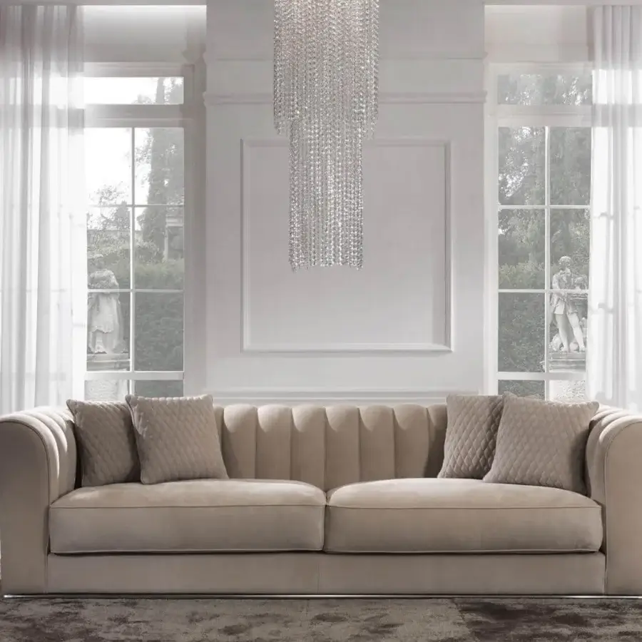 Elegant DV Home Collection Kent sofa upholstered in smooth beige textile with a sleek chrome metal base and tufted backrest