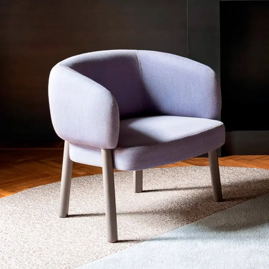 Sophisticated Bross Aretha lounge chair with curved form and light lavender textile upholstery supported by light-toned wood legs