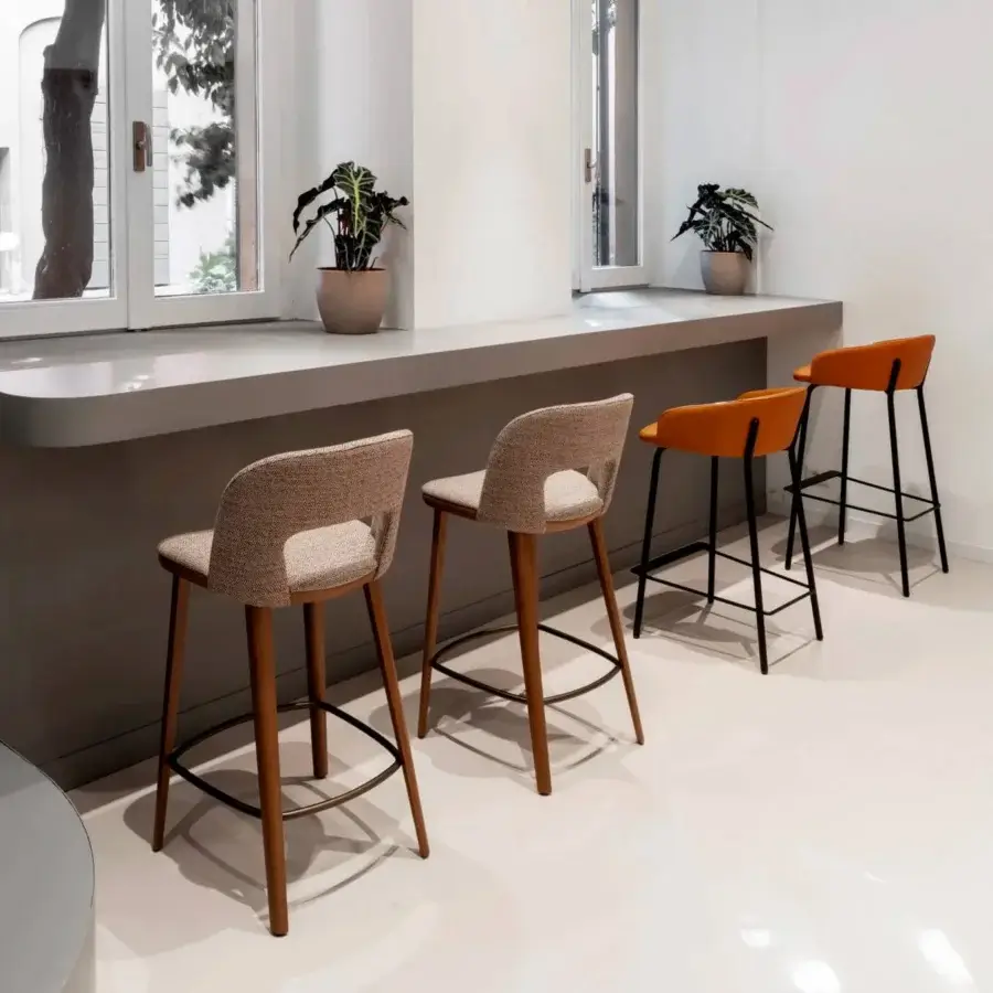 Distinguished Bross Path stool with beige fabric upholstery and curved backrest built with a wooden base and metal footrest