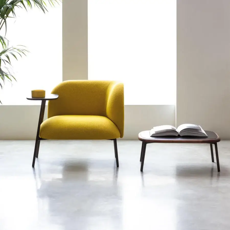Superior Bross Sit lounge chair with organic silhouette upholstered in textured matte yellow fabric and metal frame crafted in Italy