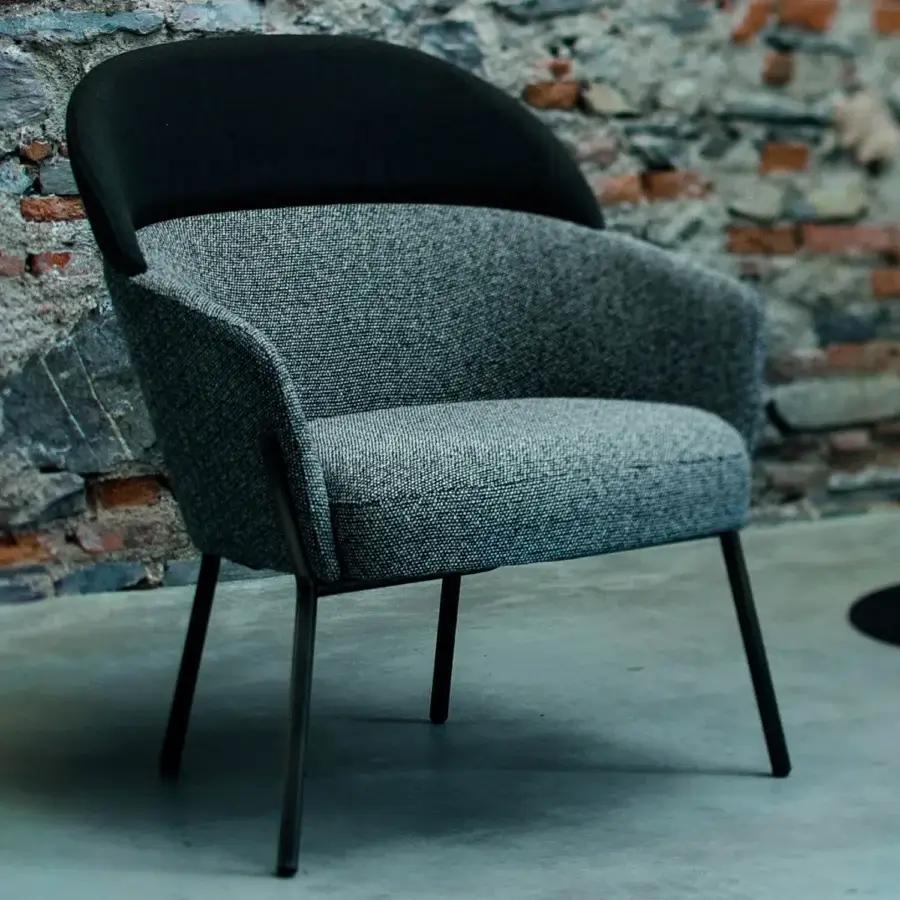 Elegant Bross Wam lounge chair upholstered in textured gray fabric with a contrasting black accent and sleek matte metal frame