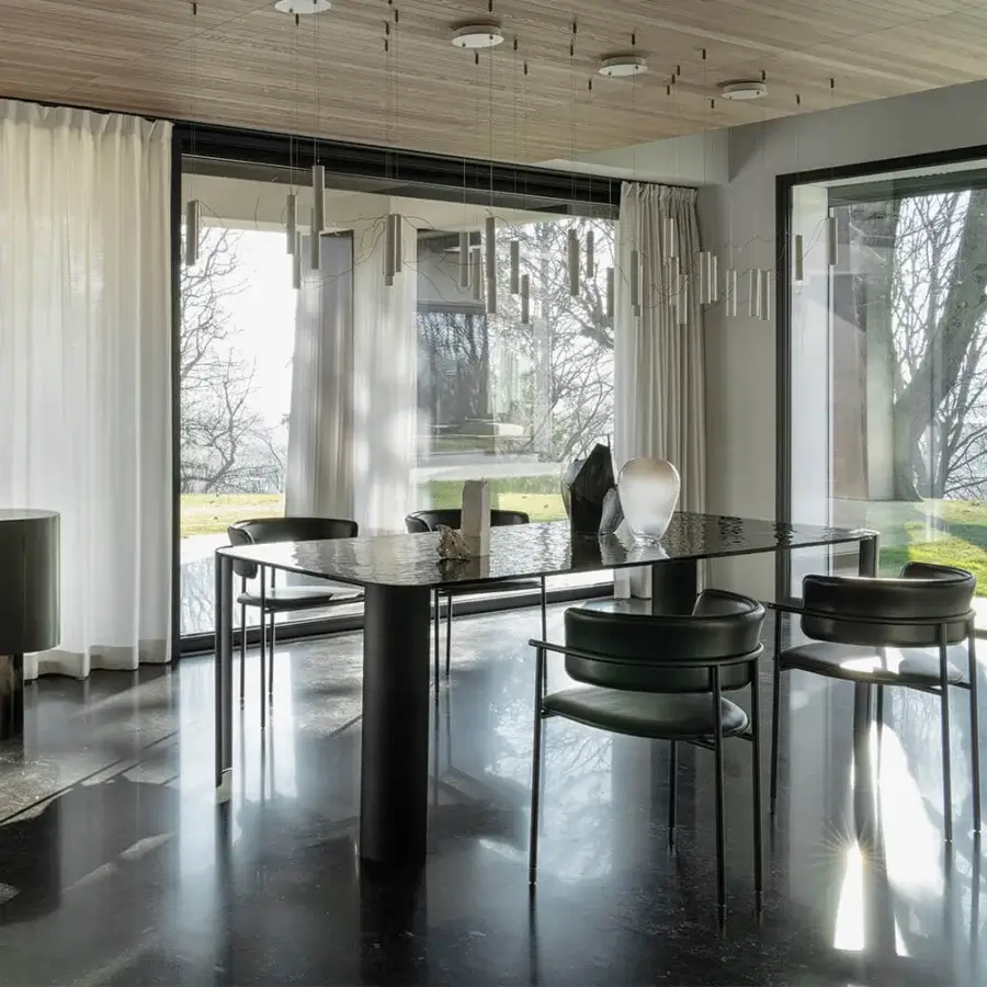 Elegant Cierre1972 Riviera table with glossy dark tabletop exhibiting lighter patterns and graceful metal legs