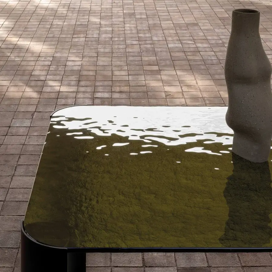 Superior Cierre1972 Riviera table with glass top exhibiting mottled olive green textures and graceful black legs