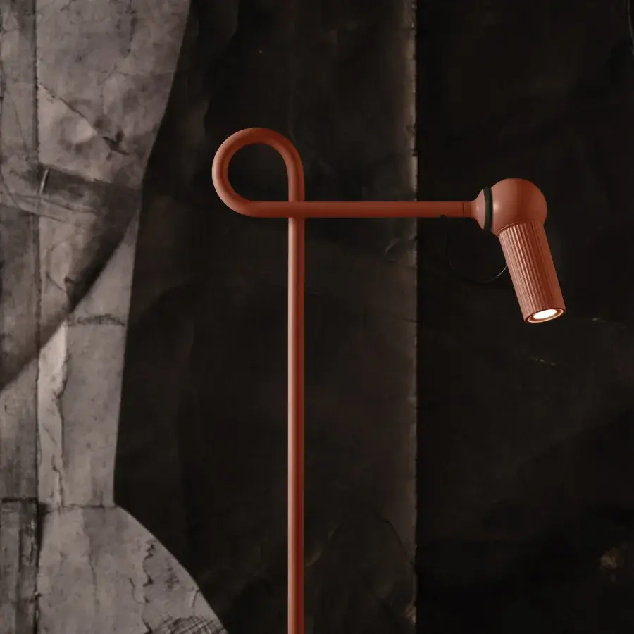 Elegant Kundalini Bird floor lamp with curving coated metal and die-cast varnished aluminum head in orange-brown