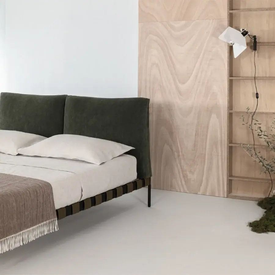 Distinguished Cierre1972 Oscar bed with dark green padded headboard and light beige bedclothes in a matte finish