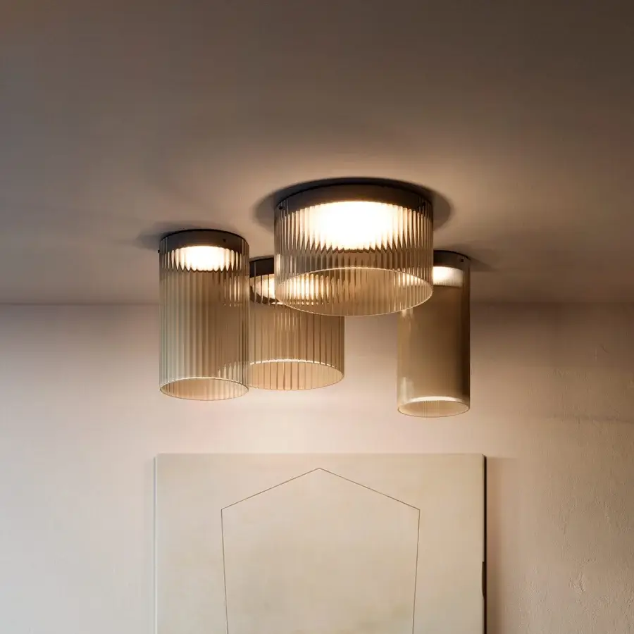 Distinguished Kundalini Giass ceiling lamp with varying heights of ribbed, light brownish blown glass and coated metal structures