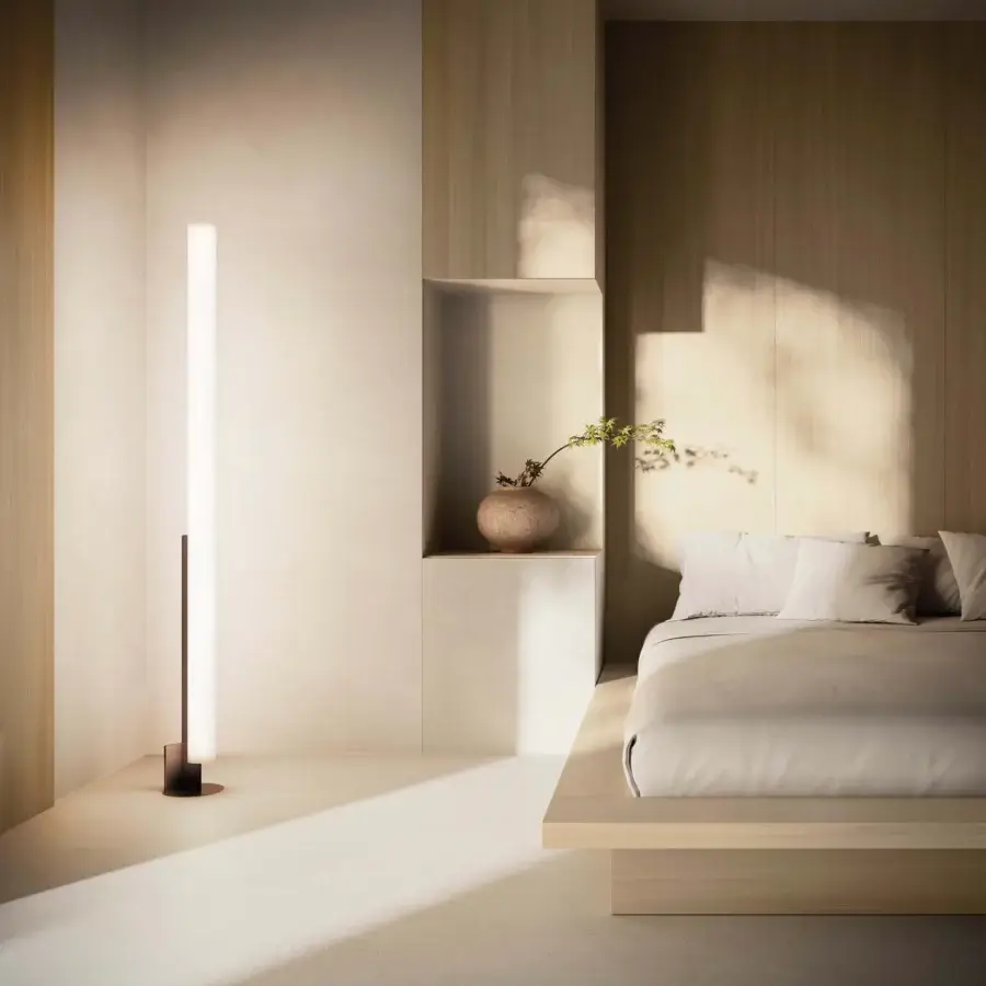 Distinguished Kundalini Model T floor lamp with a slender metallic frame and matte opal methacrylate tubular diffuser emitting warm light