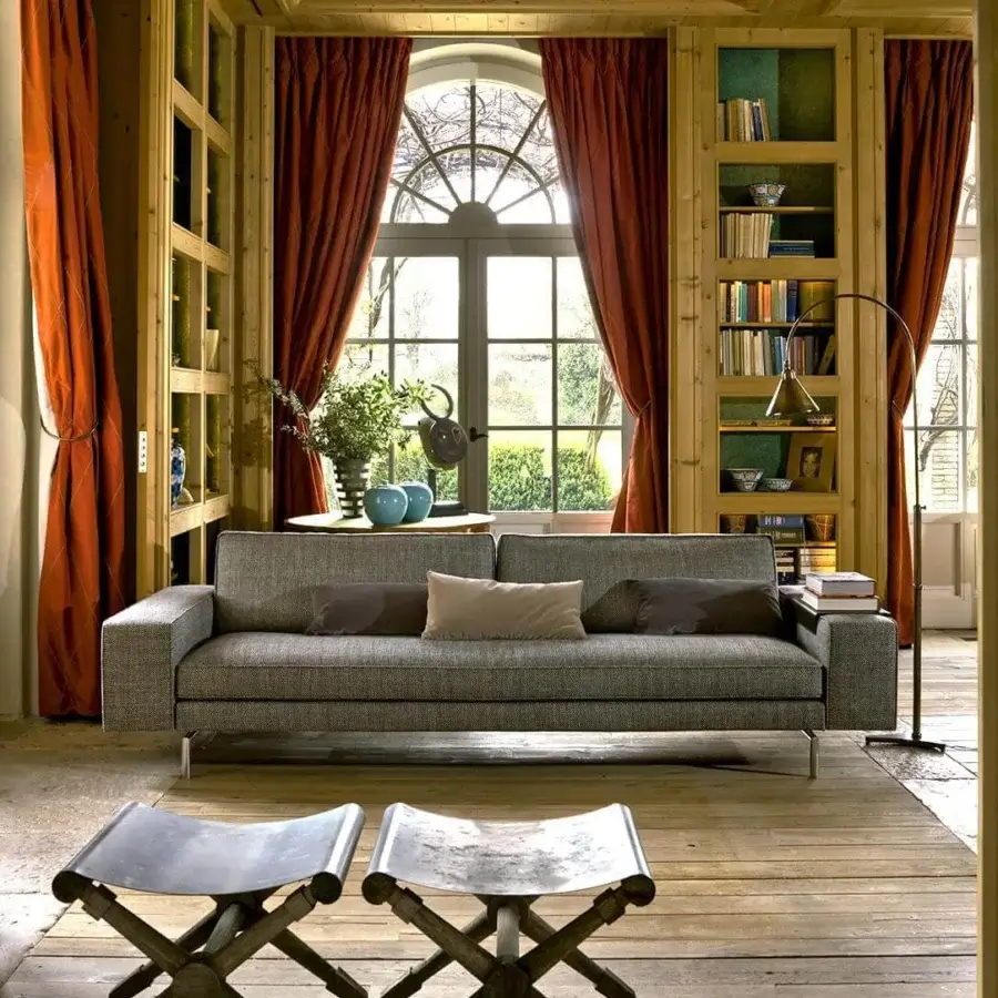 Superior Verzelloni Irving sofa upholstered in textured neutral gray textile with bronzed painted aluminium bridge feet and contrasting cushions