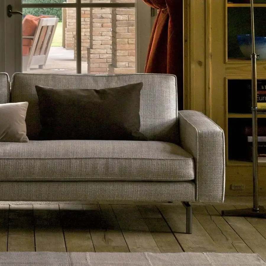 Distinguished Verzelloni Irving sofa with light grey woven textile upholstery and bronzed painted aluminum feet, accompanied by tan and brown cushions