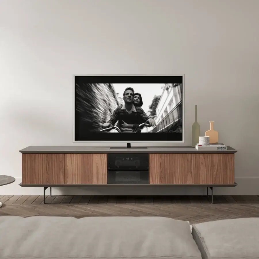 Ozzio Italia Brera TV stand, dark gray matte surface, walnut wood grain, angled metal legs, recessed handle drawers, blue interior lighting.